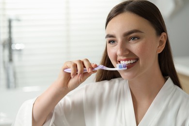 Beautiful woman brushing her teeth in bathroom