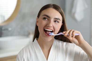 Beautiful woman brushing her teeth in bathroom