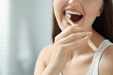 Photo of Woman brushing her teeth in bathroom, closeup. Space for text