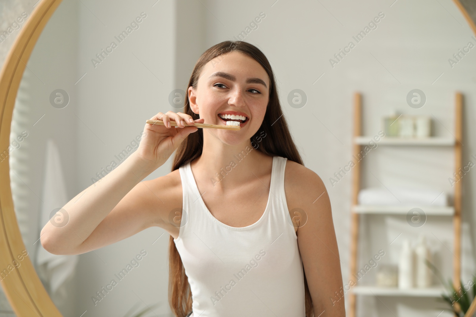 Photo of Beautiful woman brushing her teeth in bathroom