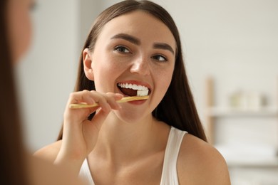 Photo of Beautiful woman brushing her teeth in bathroom