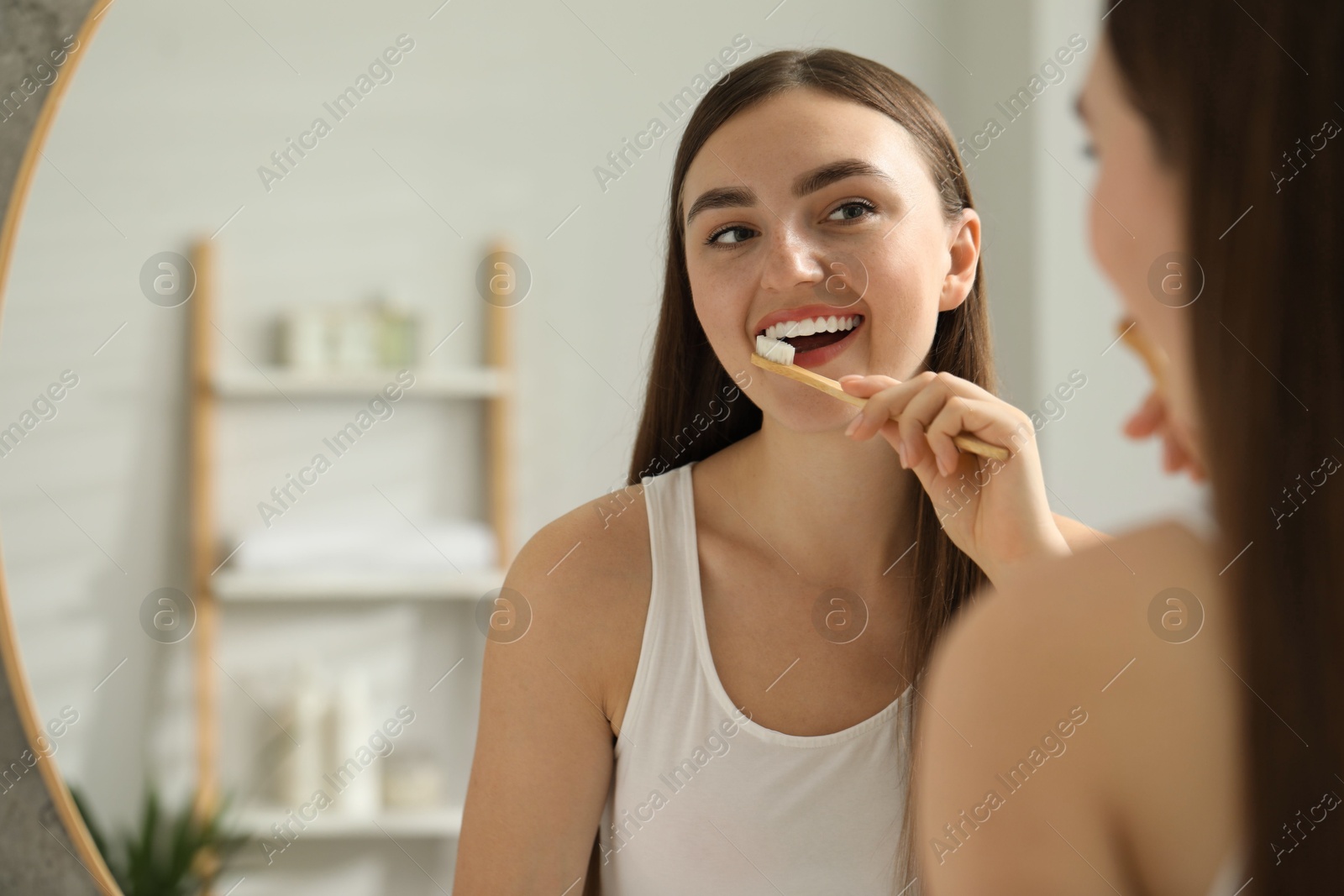 Photo of Beautiful woman brushing her teeth in bathroom