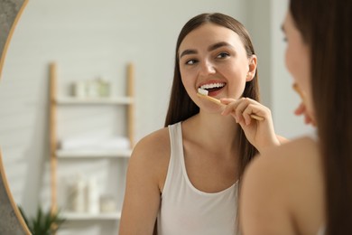 Photo of Beautiful woman brushing her teeth in bathroom