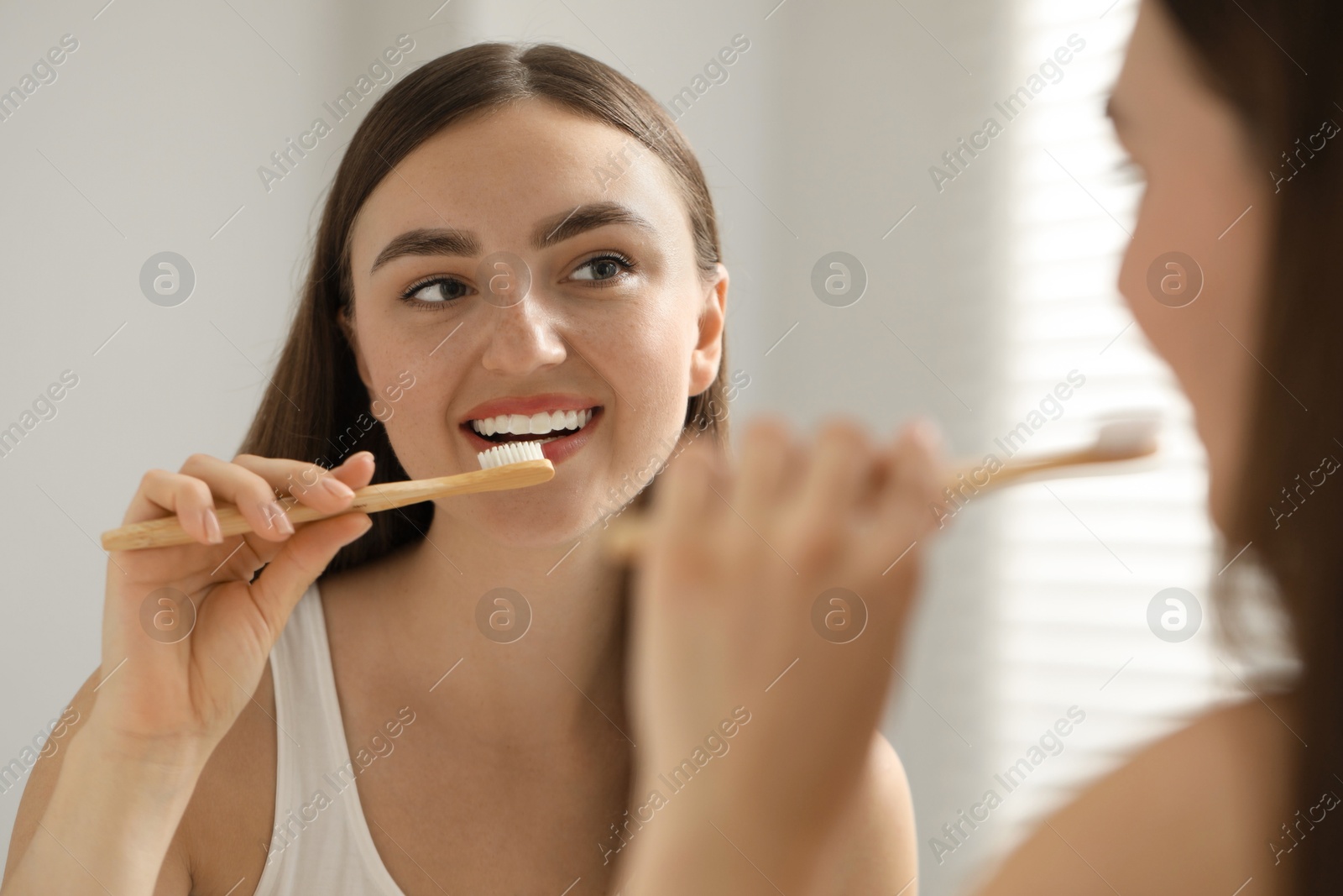 Photo of Beautiful woman brushing her teeth in bathroom