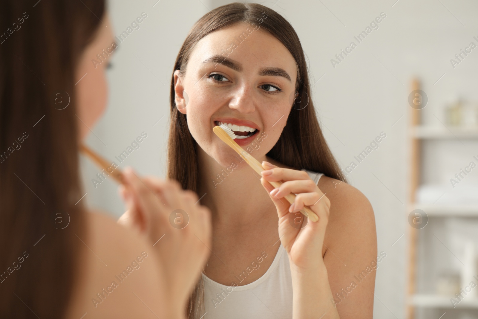 Photo of Beautiful woman brushing her teeth in bathroom