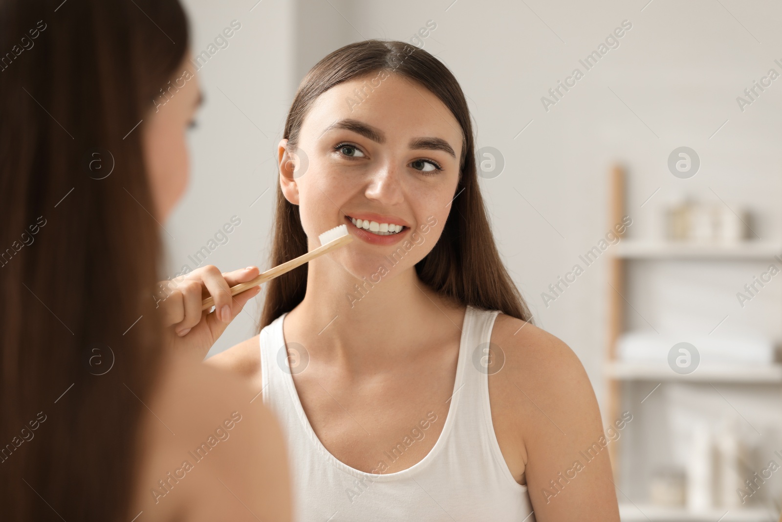 Photo of Beautiful woman brushing her teeth in bathroom