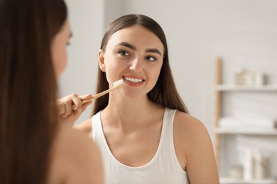 Photo of Beautiful woman brushing her teeth in bathroom