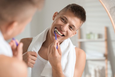 Young man brushing his teeth in bathroom