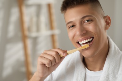 Photo of Young man brushing his teeth in bathroom