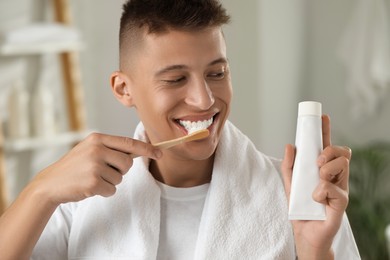 Photo of Young man brushing his teeth in bathroom