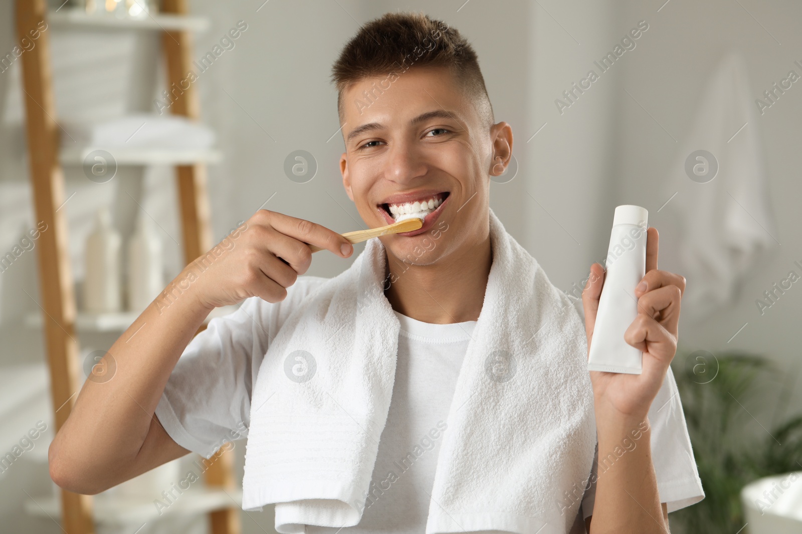 Photo of Young man brushing his teeth in bathroom