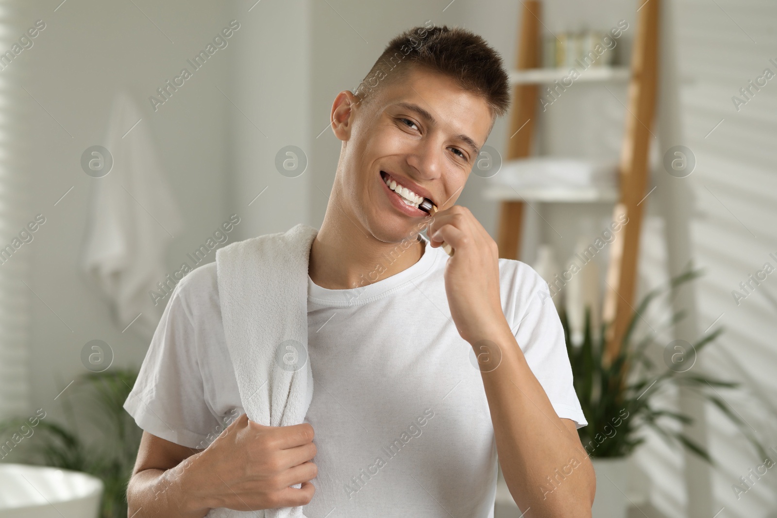 Photo of Young man brushing his teeth in bathroom