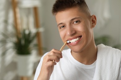 Photo of Young man brushing his teeth in bathroom