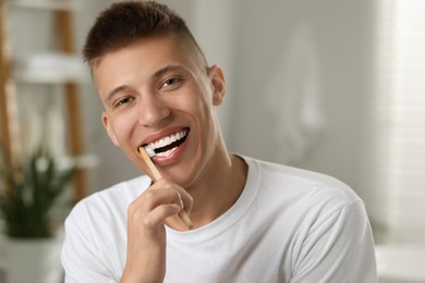 Young man brushing his teeth in bathroom