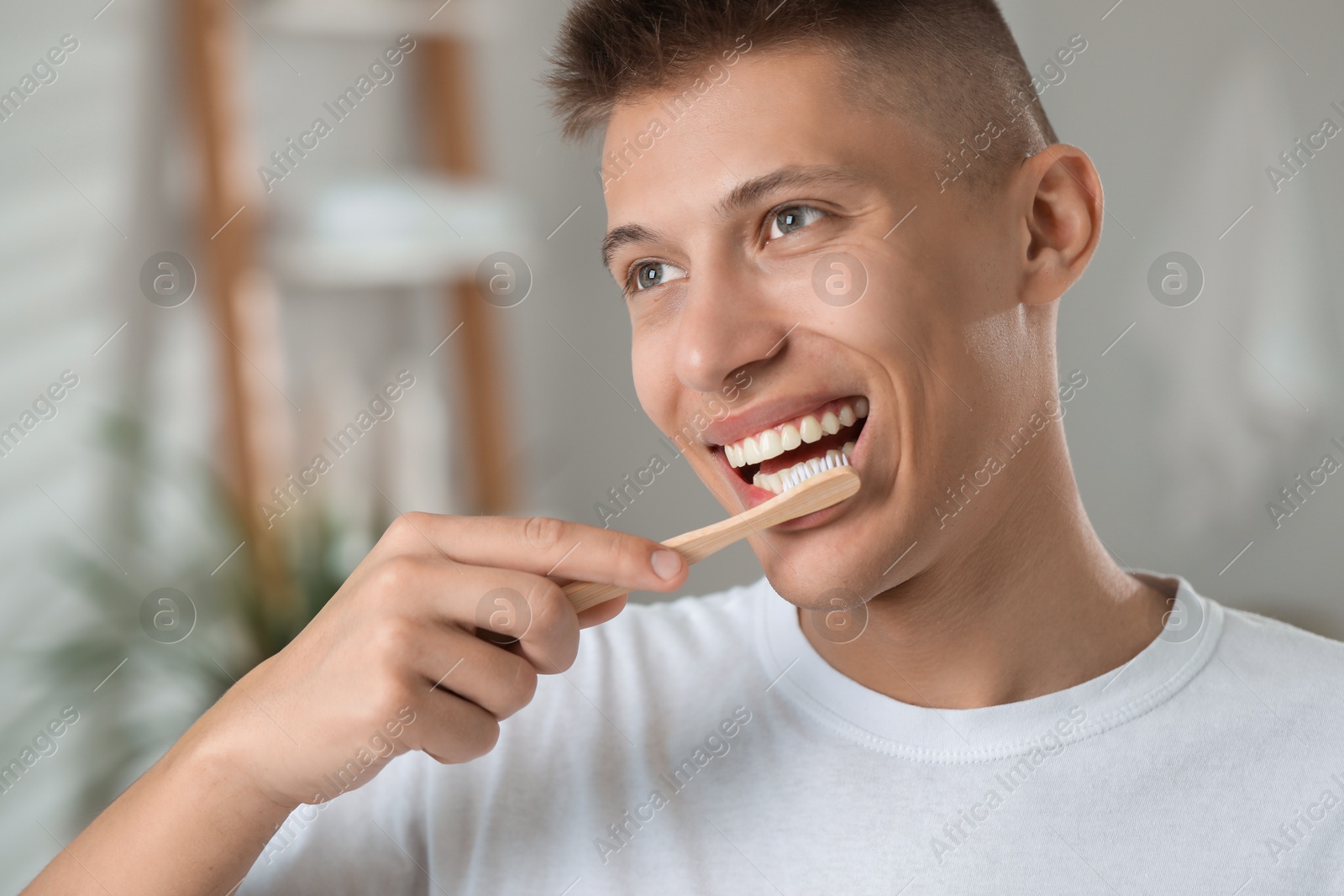 Photo of Young man brushing his teeth in bathroom