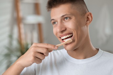 Young man brushing his teeth in bathroom