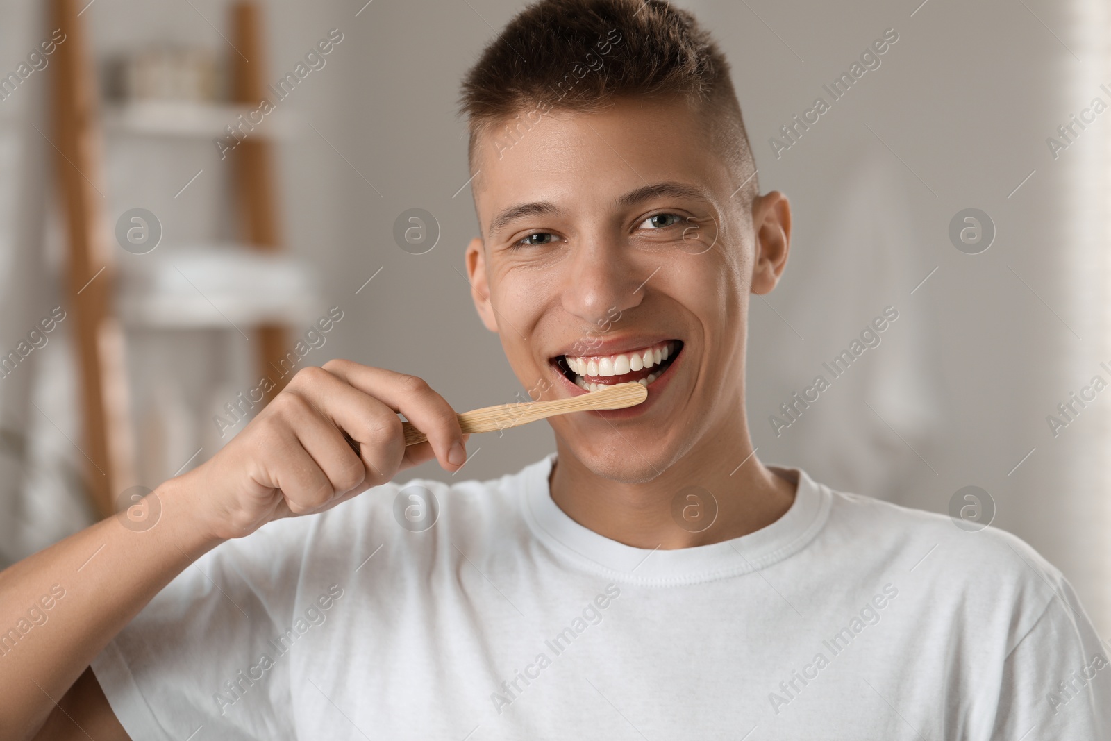 Photo of Young man brushing his teeth in bathroom