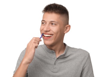 Young man brushing his teeth on white background