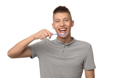 Young man brushing his teeth on white background