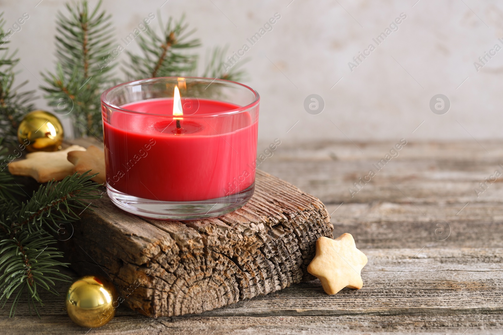 Photo of Burning candle, baubles, Christmas cookies and fir tree branches on wooden table, closeup. Space for text