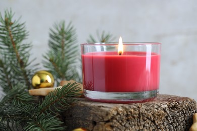 Photo of Burning candle, baubles, Christmas cookies and fir tree branches on wooden table, closeup