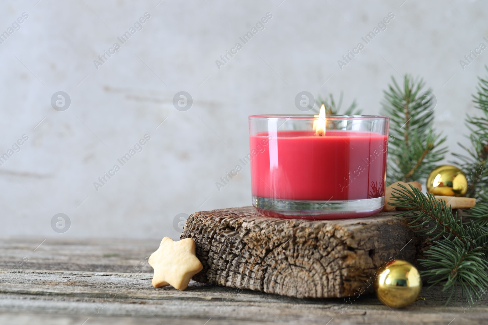 Photo of Burning candle, baubles, Christmas cookies and fir tree branches on wooden table, closeup. Space for text