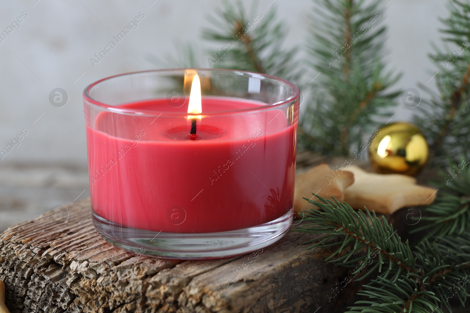 Photo of Burning candle, baubles, Christmas cookies and fir tree branches on wooden table, closeup