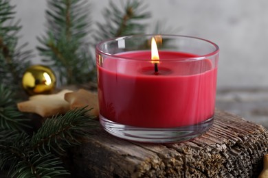 Photo of Burning candle, baubles, Christmas cookies and fir tree branches on wooden table, closeup