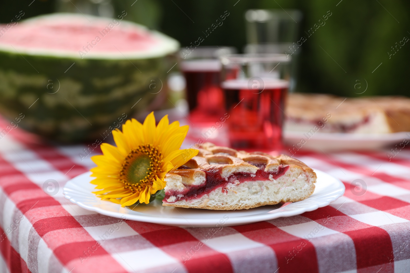 Photo of Plate with pie and sunflower on table in garden, closeup