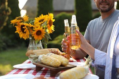 Photo of Friends with drinks enjoying picnic at table in garden, closeup