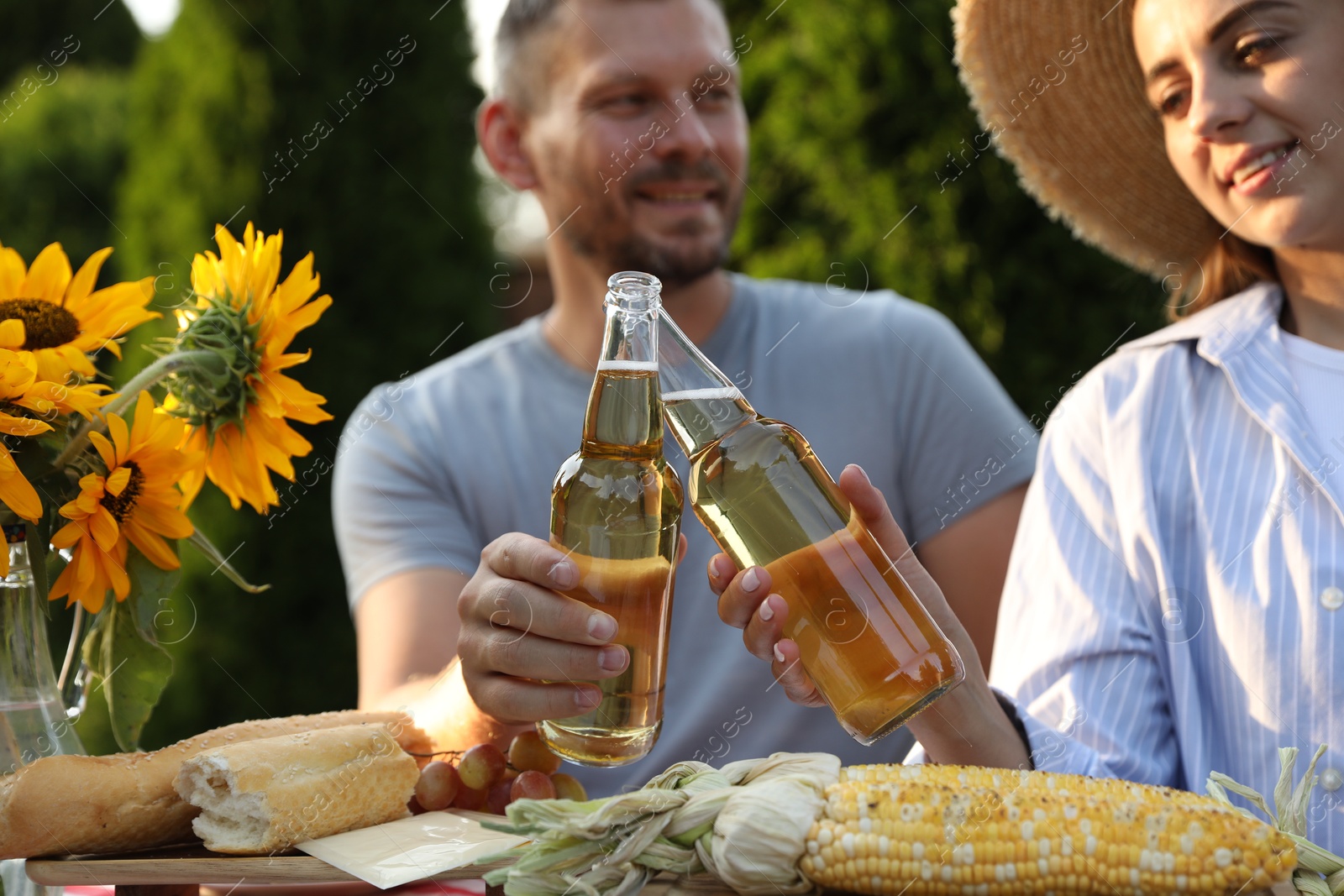 Photo of Friends enjoying picnic at table in garden, selective focus