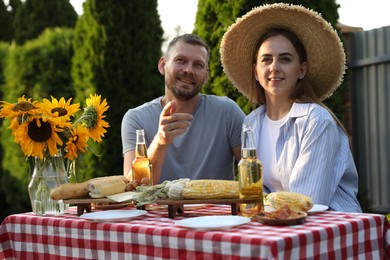 Friends enjoying picnic at table in garden