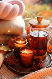 Burning candles, freshly brewed tea, sweaters and autumn decor on fabric