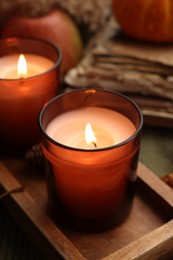 Photo of Autumn atmosphere. Burning candles on table, closeup