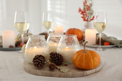 Photo of Burning candles and autumn decor on table indoors