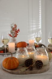 Photo of Burning candles and autumn decor on table indoors