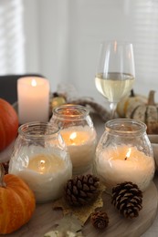 Photo of Burning candles and autumn decor on table, closeup