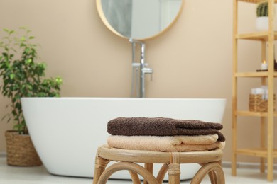 Stack of clean towels on table in bathroom