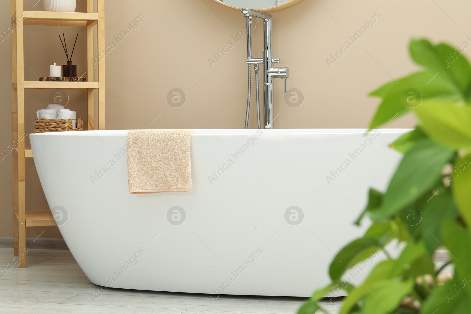 Photo of Shelving unit with decor and tub in bathroom