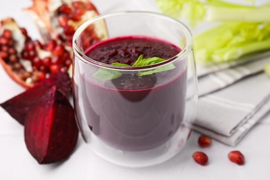 Photo of Fresh beetroot smoothie with mint in glass on white table, closeup