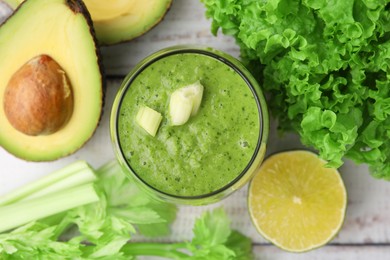 Photo of Tasty green smoothie in glass and products on wooden rustic table, flat lay