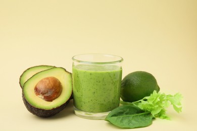 Photo of Tasty green smoothie in glass and products on beige background