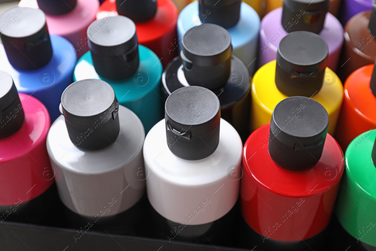 Photo of Acrylic paints of different colors in bottles, closeup