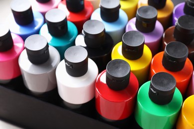 Photo of Acrylic paints of different colors in bottles on table, closeup