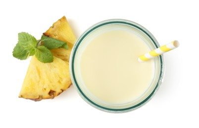 Photo of Tasty pineapple smoothie in glass, slices of fresh fruit and mint isolated on white, top view