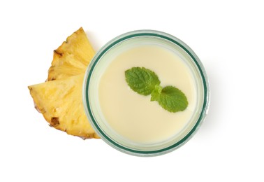 Photo of Tasty pineapple smoothie in glass and slices of fresh fruit isolated on white, top view