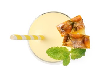 Photo of Tasty pineapple smoothie with slices of fresh fruit and mint in glass isolated on white, top view