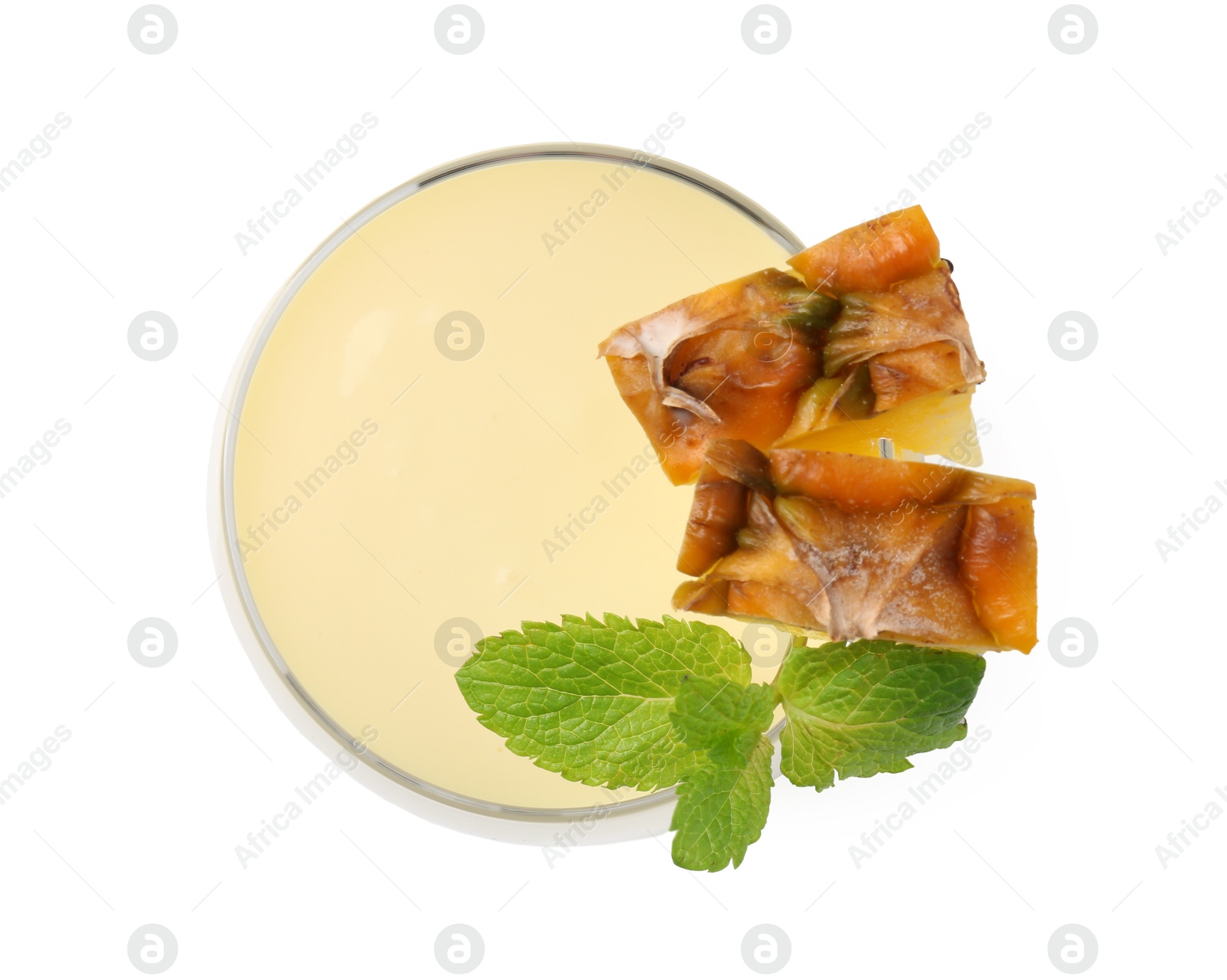 Photo of Tasty pineapple smoothie with slices of fresh fruit and mint in glass isolated on white, top view