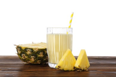 Photo of Tasty pineapple smoothie in glass and slices of fruit on wooden table against white background