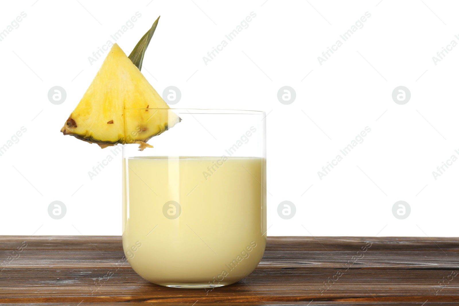 Photo of Tasty pineapple smoothie in glass and slice of fruit on wooden table against white background